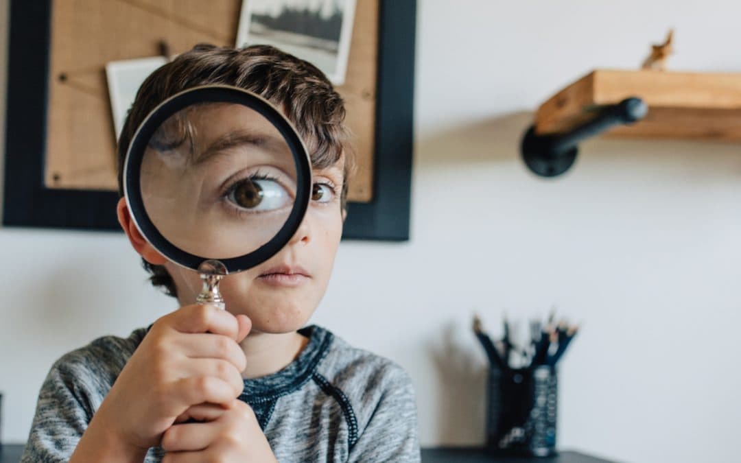 A curious child looking through a magnifying glass